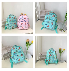 Detail view of pink and mint green children's backpacks with cartoon dinosaur prints
