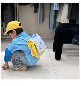 Detail view of children's canvas backpack with blue and yellow plaid patterns and straps