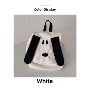 Close-up of white canvas toddler backpack featuring a cute cartoon dog face and black handle