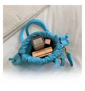 Macro view of blue mini bucket bag interior showing makeup storage capacity