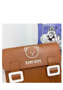 Detail view of brown PU leather kids backpack with cute white bear print and square buckles