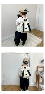 Toddler in modern home setting wearing a cute puppy canvas backpack with black ears