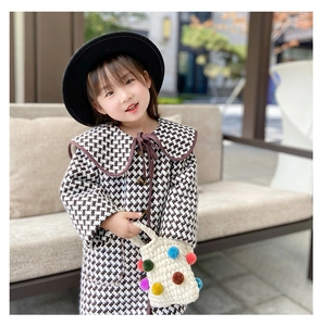 Detail of girls winter knit handbag with colorful pom-poms and elegant bow accent