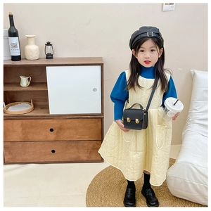 Gros plan d'une fille portant un mini sac bandoulière noir en cuir PU et une veste jaune