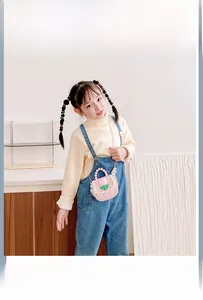 Detailed view of pink plaid kids purse with pearl handle and tulip decoration