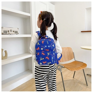 Detail of dark blue toddler backpack featuring cute colorful cartoon dinosaur prints