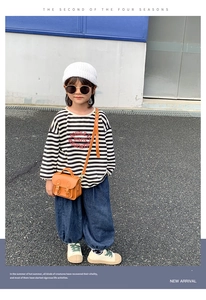 Petit sac vintage en cuir marron pour enfant porté avec un t-shirt rayé et un jean
