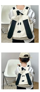 Detail of cute puppy cartoon design on canvas kids backpack with embroidered dog face