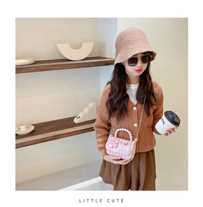 Detailed view of pink tweed mini bag with pearl handle and golden chain strap