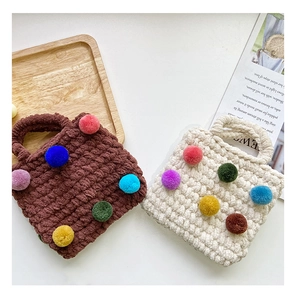 Detailed close-up of handmade crochet girl handbags with colorful pom-poms and thick texture