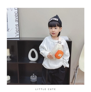 Detail of child wearing a cream and orange crossbody chest bag with adjustable strap