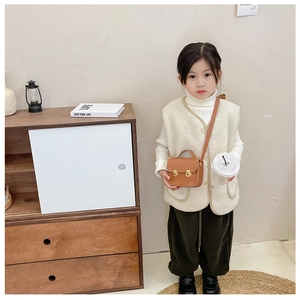 Vue détaillée du petit sac bandoulière vintage marron pour enfant avec fermoirs dorés