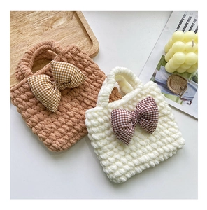 Detail of handmade knit mini handbags with thick plush yarn and stylish bow accents