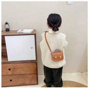 Détail d'un mini sac bandoulière marron pour fille avec doubles boucles métalliques