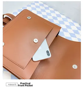 Detailed view of brown PU leather backpack front pocket with magnetic snap closure