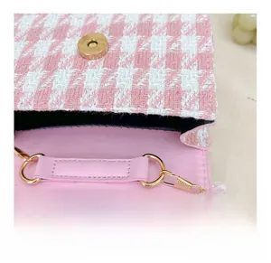 Detail of pink houndstooth kids purse with magnetic buckle and detachable gold chain hook