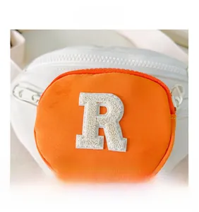 Close-up of kids waist bag featuring orange front pocket and chenille R letter patch