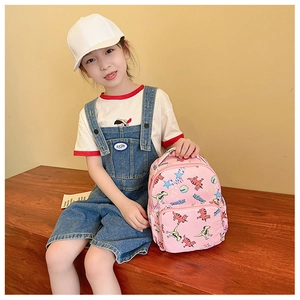 Close-up of pink toddler backpack featuring cute cartoon dinosaur and star prints