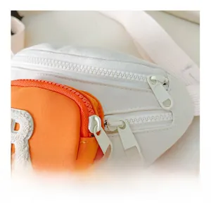 Detail of smooth resin zippers and embroidered letter R on children's nylon chest bag