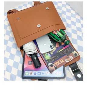 Internal storage detail of PU leather backpack showing tablet, phone and umbrella