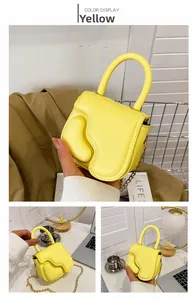 Detail of bright yellow mini handbag with wavy fluid texture and golden chain strap