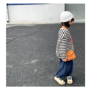 Sacoche vintage orange pour enfant portée avec jean et t-shirt à rayures