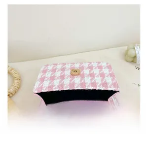 Internal view showing pink leather lining and magnetic snap on houndstooth bag