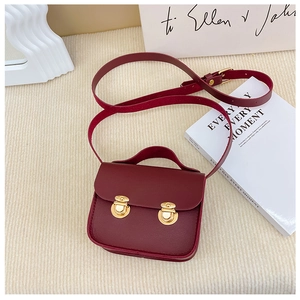 Détail du mini sac bandoulière rétro en cuir bordeaux avec fermoirs dorés