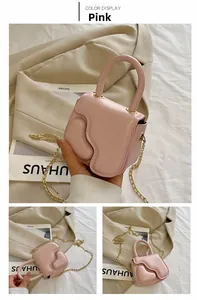 Detailed view of mini pink PU leather handbag with wavy flap and gold chain strap