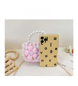 Detailed view of mini pink tweed purse with floral decor and pearl handle vs phone size
