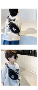 Détail du sac de poitrine en nylon noir pour enfant avec broderie NY et sangle à lettres
