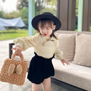 Winter kids knitted shoulder bag with bow knot shown in a stylish outdoor autumn scene