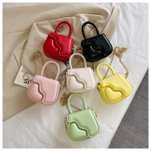 Multiple mini cross-body bags in vibrant colors with heart embossed flap and gold chain strap
