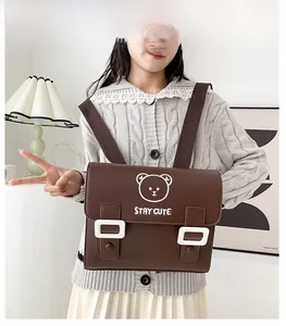 Detail of a brown PU leather preppy backpack featuring a cute white bear and stay cute print