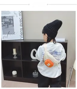 Rear view of kid's white canvas crossbody bag featuring a bright orange mini coin pouch