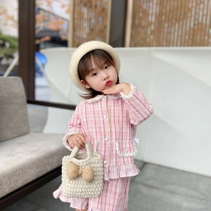 Pink tweed girls outfit with pearl buttons and knit bow handbag for 2025 winter style