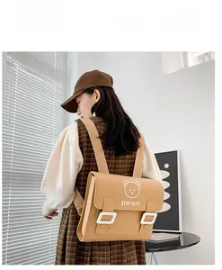 Detail of light brown PU leather school backpack featuring a cute bear print and flap closure