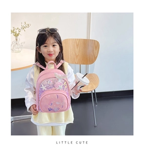 Fillette portant un sac à dos sirène rose avec paillettes et détails de coquillages