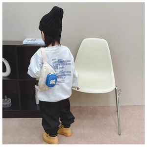 Kid street style set with white logo sweatshirt, black pants and cream-blue crossbody bag
