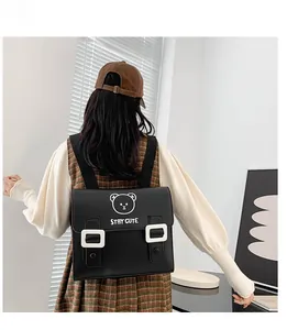 Detail of cute bear print and STAY CUTE text on black PU leather school backpack