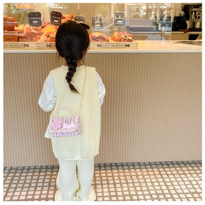 Detailed view of pink tweed mini bag with pearl handle and golden chain for little girls