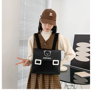 Detail of black PU backpack featuring a cute bear print and stay cute text for children