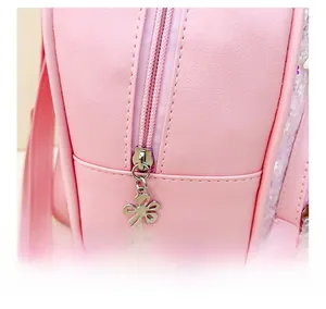 Détail du sac à dos rose pour enfant avec fermeture éclair en métal et breloque fleur