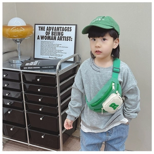 Detailed view of green and white color-block kids crossbody bag with letter R patch