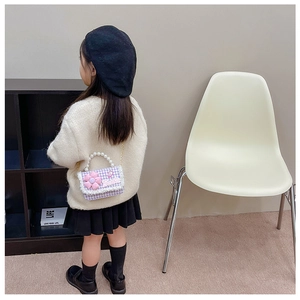 Detail view of child model wearing purple tweed flower bag with pearl handle and chain strap