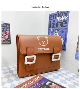 Detail of cute bear embroidery and dual buckles on a brown PU leather vintage backpack