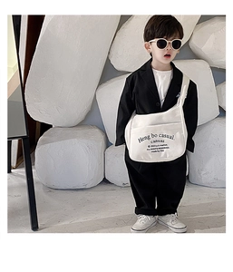 Detailed close-up of a white canvas crossbody bag for kids with black letter prints