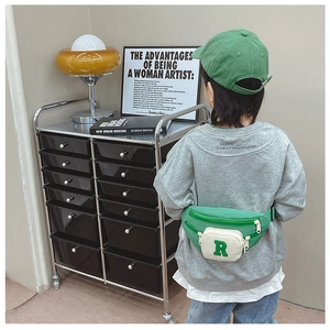 Close-up of green kids chest bag with letter R embroidery and adjustable strap