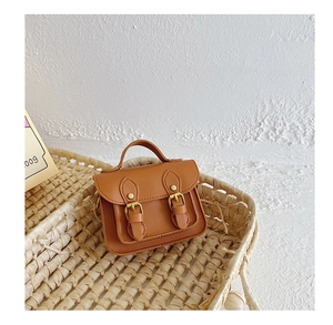 Gros plan d'un mini sac Cambridge marron à doubles boucles dans un panier tressé