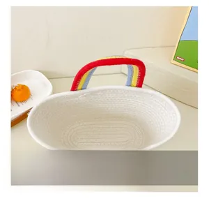 Détail d'un mini panier tressé en coton blanc avec des poignées arc-en-ciel colorées